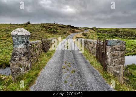 Eine Steinbrücke, die über einen Bach in ländlicher Grafschaft geht Galway Irland Stockfoto