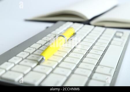 Weiße Aluminium-Tastatur mit gelbem Bürotisch Stockfoto