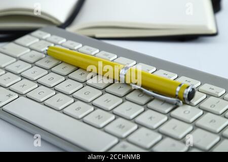 Weiße Aluminium-Tastatur mit gelbem Bürotisch Stockfoto