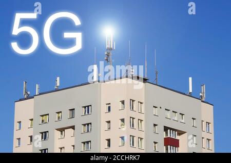 5G-, GSM- und Fernsehantennen auf dem Dach des Gebäudes vor blauem Himmel Stockfoto