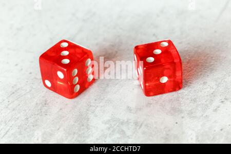 Zwei durchscheinende rote Würfelwürfelwürfelchen auf weißem Brett, das hart zeigt Sechs (doppelte Zahl drei) Stockfoto