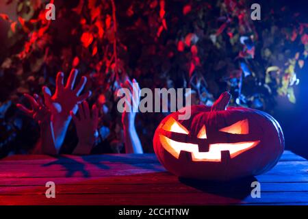 Halloween Kürbis auf dem Hintergrund der toten Männerhände. Stockfoto