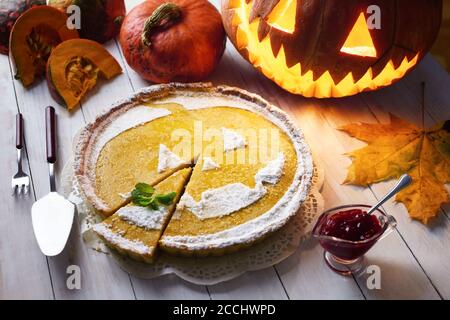 Süße hausgemachte halloween Kürbiskuchen mit Minzeblatt. Jack-o-Laterne, Esche Blätter und Preiselbeere Marmelade herum Stockfoto