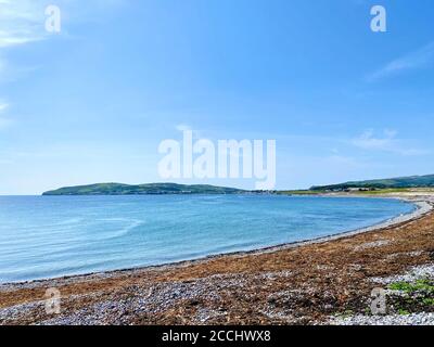 Blick über den Kiesstrand und das Meer in Richtung der Küstenstadt Port St Mary's, Isle of man Stockfoto