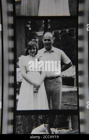 Feine Schwarz-Weiß-Fotografie aus den 1970er Jahren eines stolzen Vaters, der mit seiner Tochter bei einem schönen Familientreffen steht. Stockfoto