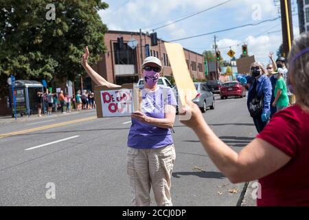 Portland, OREGON, USA. August 2020. NANCY YUILL aus Portland hält ein Schild mit der Aufschrift "Dejoy Out" vor dem Rose City Post Office während des Samstag, den 22. August 2020, von Moveon.org in Portland Oregon organisierten Aktionstages "Save the Post Office". "Die Freude bedroht unsere Demokratie, und ich verstehe den Zusammenhang zwischen der Entfinanzierung unserer Postdienste, unserem Wahlrecht und Rassengerechtigkeit", sagte YUILL. Demonstranten tauchten bei lokalen Postämtern im ganzen Land auf, um das Postamt vor Präsident Trump zu retten und um den Rücktritt von Postmeister General Louis DeJoy zu bitten. (Kredit Imag Stockfoto