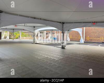 Schulen bereiten sich auf das persönliche Lernen vor, indem sie während der Coronavirus-Pandemie Zelte auf der Blacktop für Klassenräume im Freien errichten. Stockfoto