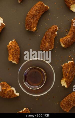 Türkische Sesambagel in Scheiben auf dunkler Oberfläche mit einem Glas Tee. Stockfoto