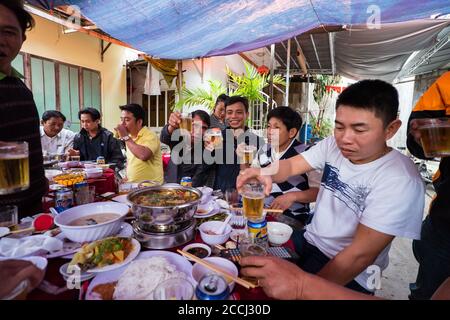 Hoi an / Vietnam - 18. Januar 2020: Gruppe vietnamesischer Männer, die während der Beerdigungsfeier Bier trinken Stockfoto