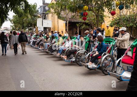 Hoi an / Vietnam - 18. Januar 2020: Gruppe von asiatischen Touristen sitzen auf Rikscha im beliebten historischen Zentrum von Hoi an Stockfoto