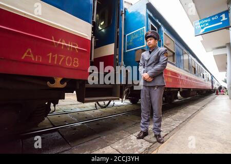 Hue / Vietnam - 20. Januar 2020: Schaffner steht vor dem Zugauto am Bahnhof Hue Stockfoto