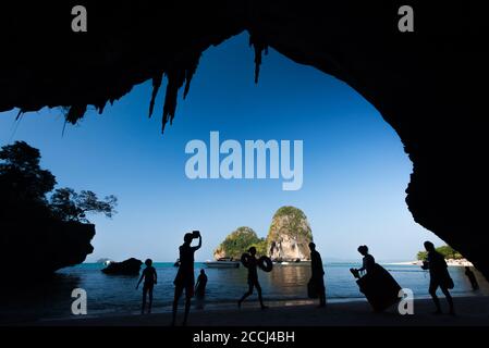 Eine Gruppe von Touristen fotografieren und entspannen am Rai Leh Strand im sonnigen Sommer, Blick aus dem Inneren der Höhle Blick aus. Krabi, Thailand. Stockfoto