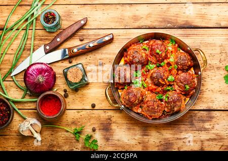 Fleischbällchen in Tomatensauce mit Spargelbohnen auf Holztisch Stockfoto