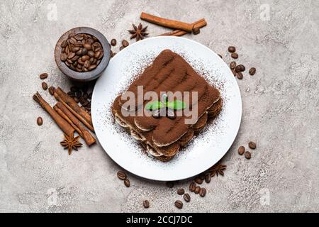 Klassisches Tiramisu Dessert auf Keramikplatte auf Betongrund Stockfoto