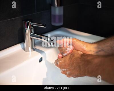 Handwäsche Körperpflege Mann waschen Hände reiben Seife für 20 Sekunden folgenden Schritten, Reinigung der Handgelenke und Spülen unter Wasser zu Hause Badezimmer. Stockfoto