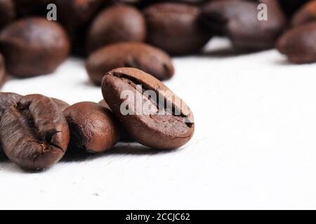 Nahaufnahme von gerösteten Kaffeebohnen auf weiß gewaschenen Hölzern Sockel Stockfoto