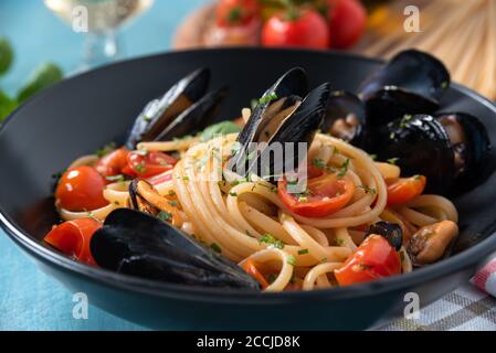Teller mit leckeren Spaghetti mit Kirschtomaten und Muschelsauce, ein typisch italienisches Essen Stockfoto