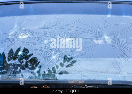 Zerbrochenes Glas. Das Autoglas hat bei einem Unfall gesprungen. Panzerglas nach dem Aufprall. Glas mit einem Film verstärkt, nachdem er von einer Kugel getroffen. Stockfoto