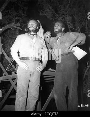 TIM HOLT und HUMPHREY BOGART am Set das Rauchen während der Pause beim Filmen DES SCHATZES DER SIERRA MADRE 1948 Regie / Drehbuch JOHN HUSTON Roman B. Traven Warner Bros. Stockfoto