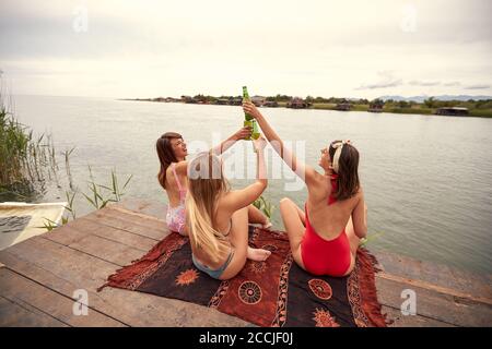 Junge attraktive Mädchen im Bikini, die Toast am Ufer machen Des Sees bei sonnigem Wetter Stockfoto