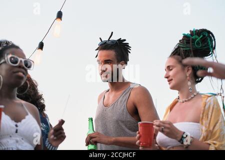 Junger Mann mit Spaß auf einer Party zusammen mit seinem Freunde im Freien Stockfoto