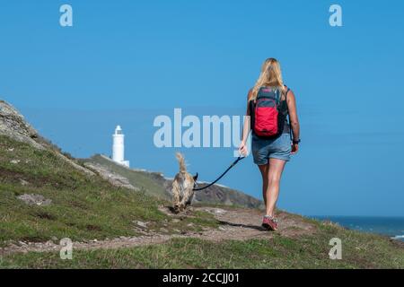 Eine Frau, die mit einem Hund entlang der Südwestküste Weg zum Startpunkt in der South Hams, Devon. Stockfoto