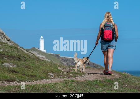 Eine Frau, die mit einem Hund entlang der Südwestküste Weg zum Startpunkt in der South Hams, Devon. Stockfoto