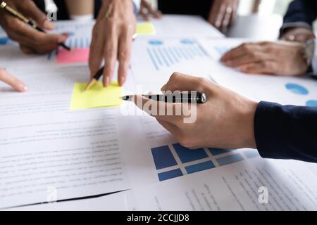 Verschiedene Geschäftsleute arbeiten gemeinsam mit ihren Mitarbeitern an Papierkram im Büro Stockfoto