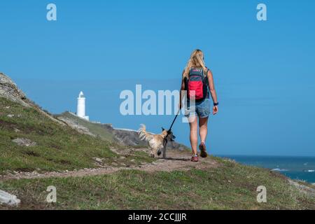 Eine Frau, die mit einem Hund entlang der Südwestküste Weg zum Startpunkt in der South Hams, Devon. Stockfoto