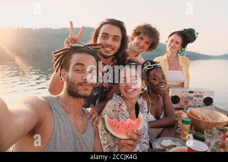 Portrait der glücklichen Gruppe von Freunden lächelnd und posiert an Kamera machen sie Selfie Portrait während Picknick im Freien Stockfoto