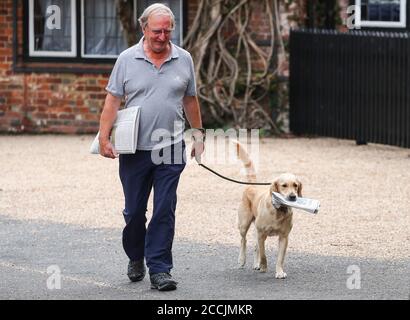 Beaulieu, New Forest. August 2020. Wetter in Großbritannien. Ein Mann und sein Hund sammeln die Morgenblätter (Telegraph und die Zeiten) während einer Pause vom Wetter an einem ansonsten grau-nassen Morgen in Beaulieu. Credit Stuart Martin/ Alamy Live News Stockfoto