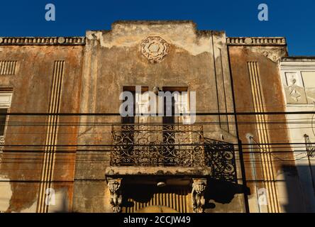 Verlassene Fassade des Kolonialhauses mit Stuck und Balkon von Sonne, Merida, Yucatan, Mexiko erhellt Stockfoto