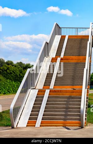 Die Treppe führt über den Highway mit blauem Himmel und weißen Wolken, Karrierekonzept, vertikalem Bild, Kopierraum. Stockfoto