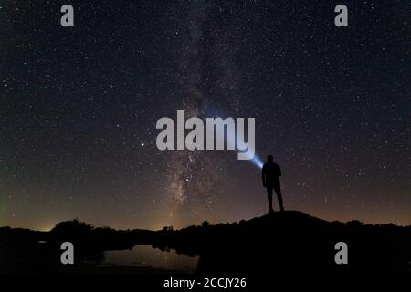 Nachtlandschaft mit Milchstraße und menschlicher Silhouette. Stockfoto