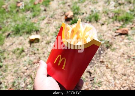 Große McDonald's Pommes, in der Hand gehalten, draußen, sonniger Tag, 2020 Stockfoto