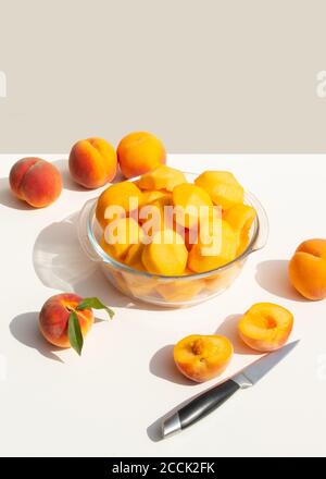 Ein Teller mit halbierten geschälten Pfirsichen. Ernte für hausgemachte Pfirsichmarmelade. Stockfoto