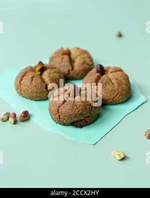 Traditionelle hausgemachte marokkanische festliche Ghoriba Cookies mit Pistazien Nüsse auf trendigen minzfarbenen Hintergrund. Stockfoto