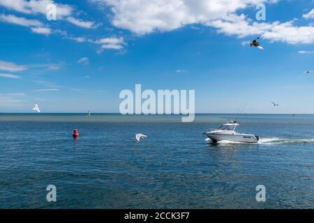 Mudeford Quay, Vereinigtes Königreich - 16 July 2020: Motorboot in Mudeford Quay, Mann fährt kleine Motorboot während sonnigen Tages und schönen heißen Wetter Stockfoto