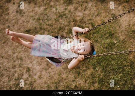 Glückliches kleines Mädchen auf einer Schaukel Stockfoto