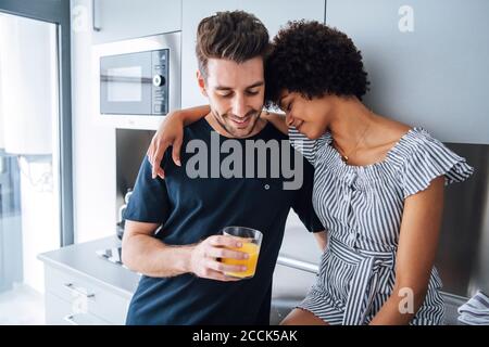 Romantisches multiethnisches Paar in der Küche des Penthouse Stockfoto