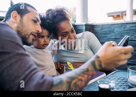 Nahaufnahme eines Mannes, der Selfie mit der Familie im Speisesaal gemacht hat Zu Hause Stockfoto