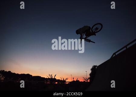 Silhouette junger Mann Durchführung Stunt mit Fahrrad gegen klaren Himmel Bei Sonnenuntergang Stockfoto