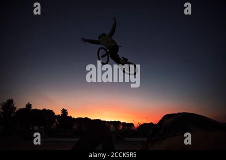 Sorglose Silhouette Mann Durchführung Stunt mit Fahrrad gegen klaren Himmel Bei Sonnenuntergang Stockfoto