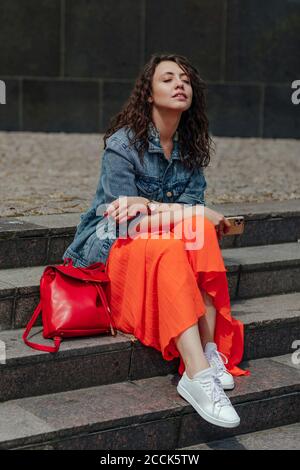 Junge Frau mit geschlossenen Augen sitzt auf Treppen genießen die So Stockfoto