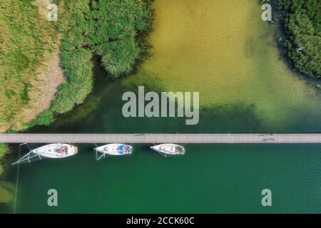 Deutschland, Mecklenburg-Vorpommern, Yachten liegen an der Pier, die sich über das grüne Ufer des Nationalparks Lagune von Vorpommern erstreckt Stockfoto