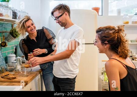 Lächelnde Köchin mit Studenten an der Küchentheke beim Kochen Schule Stockfoto