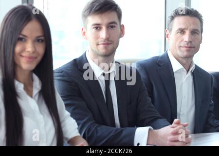 Business-Leute sitzen in einer Reihe und arbeiten, Fokus auf hübsche Frau Stockfoto