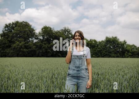 Junge Frau am Telefon in einem Getreidefeld in Die Landschaft Stockfoto