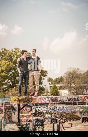 Zwei Jungen im Teenageralter hängen in einem alten heruntergekommenen Industriegebiet Stockfoto