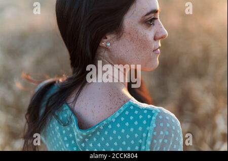 Nahaufnahme einer jungen Frau mit Sommersprossen im Gesicht, die wegschaut Auf dem Bauernhof Stockfoto